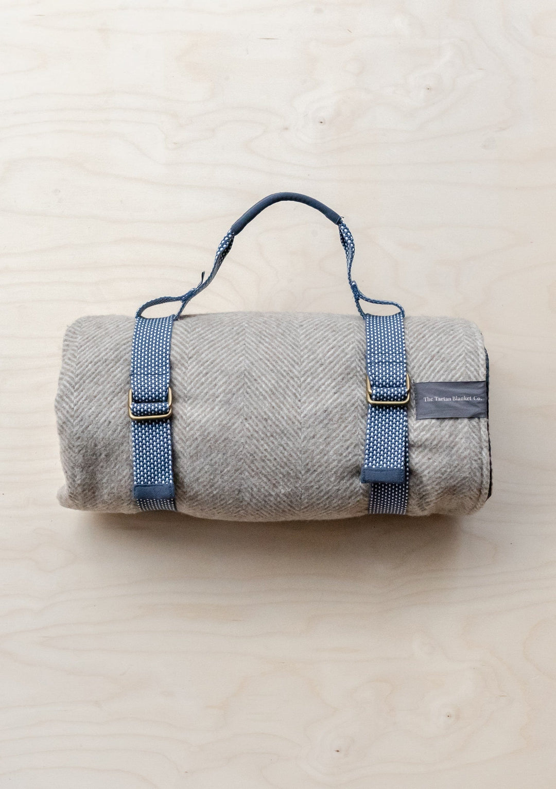 TBCo Recycled Picnic Carrier in grey with adjustable navy straps and brass buckles, designed for portable blanket transport