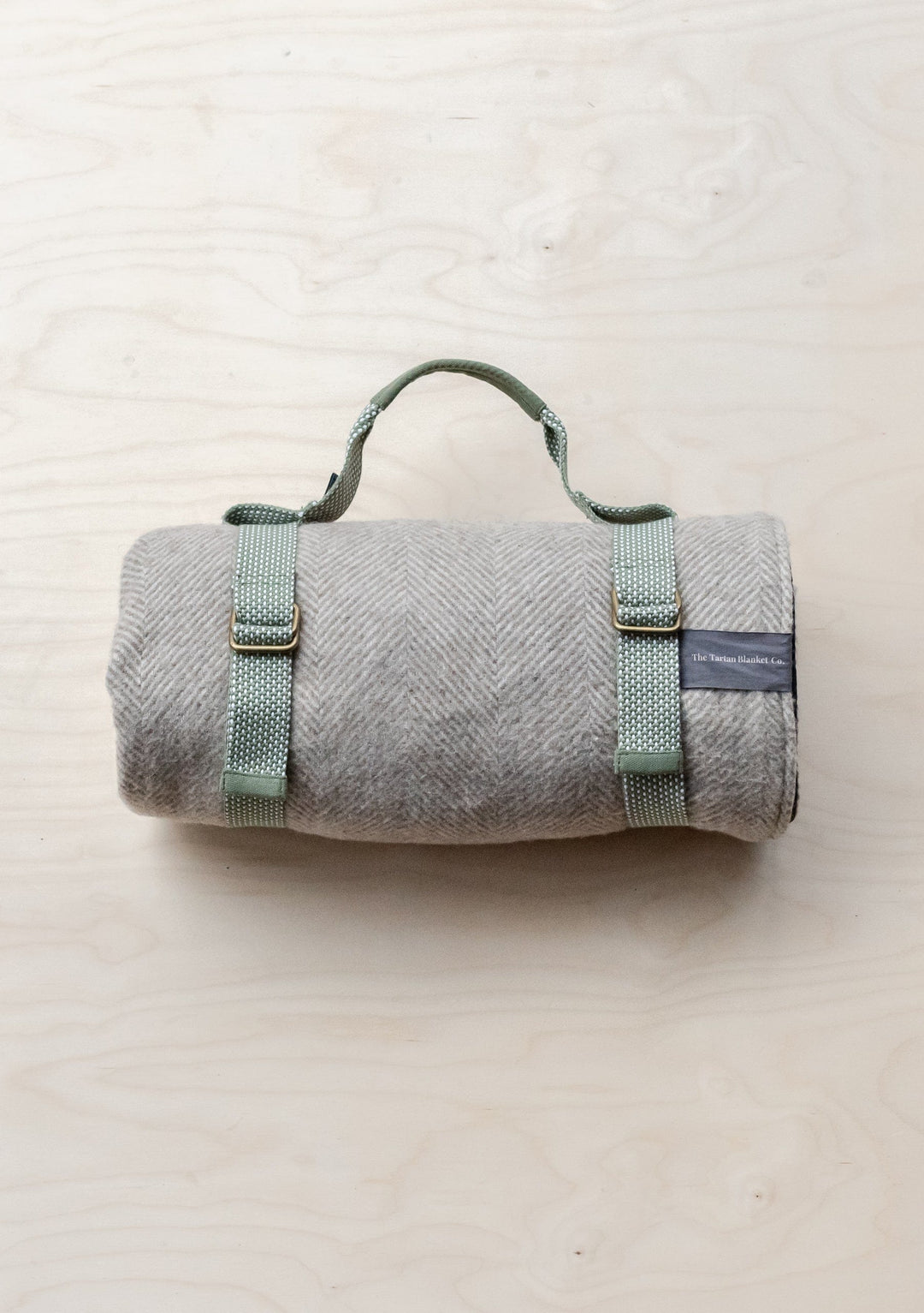 Grey TBCo Recycled Picnic Carrier with sage green straps rolled in portable blanket carrying position