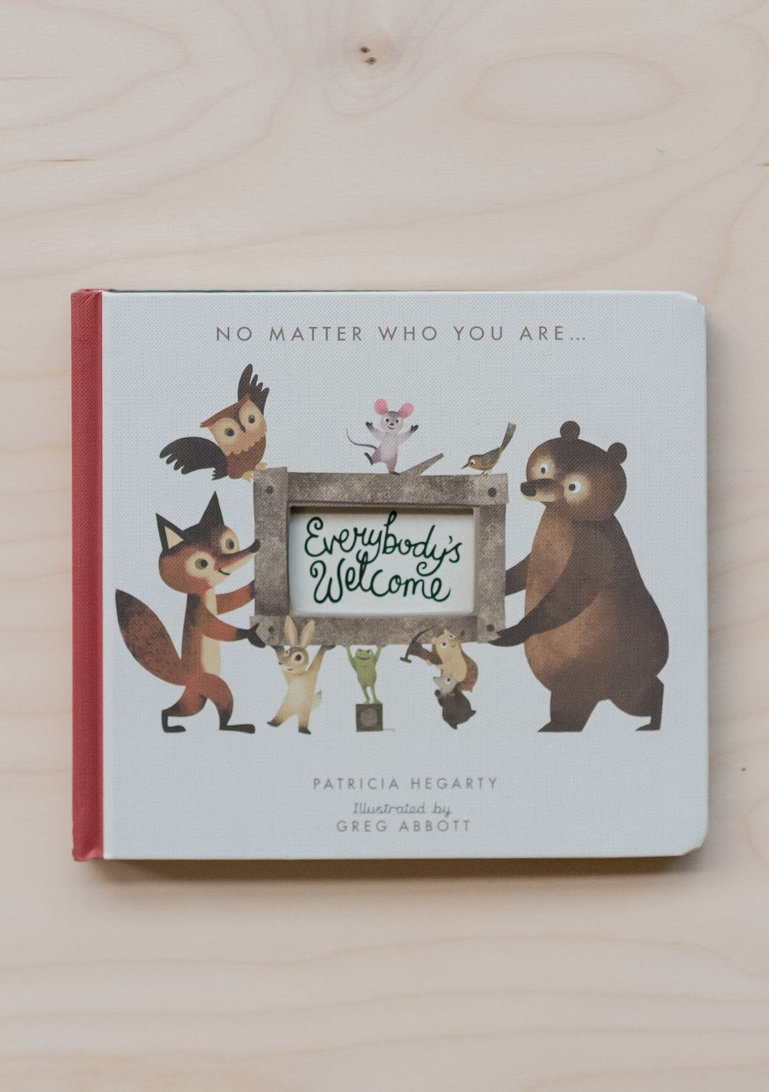 TBCo Everybodys Welcome childrens book cover showing woodland animals holding a welcome sign, illustrated by Greg Abbott