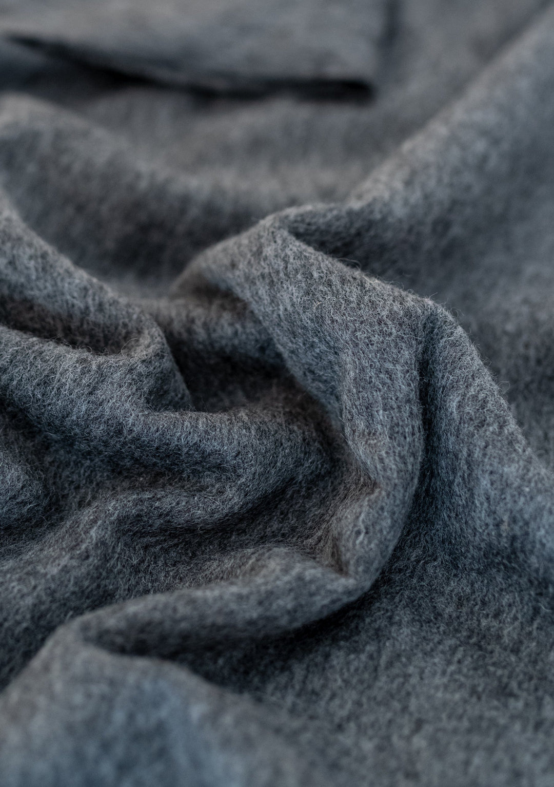 TBCo Lambswool Small Blanket in Charcoal Melange shown with soft textured folds displaying its luxurious woollen weave
