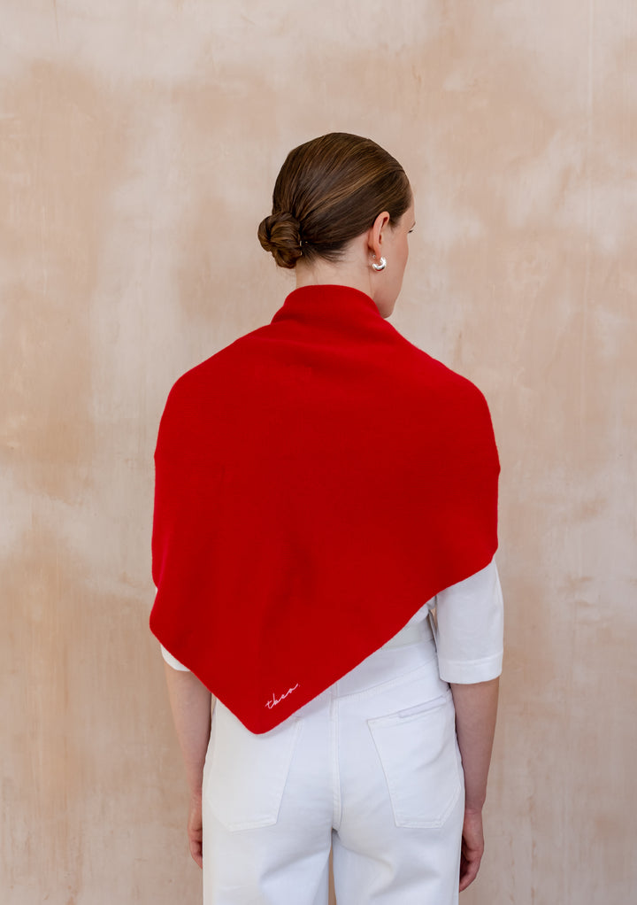 Woman seen from behind wearing a Large Merino Triangle Scarf in Red by TBCo over a white outfit