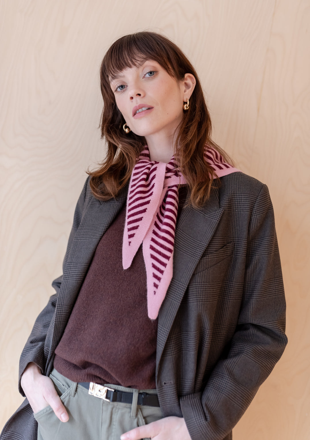 TBCo Merino Triangle Scarf in pink and burgundy stripes styled with grey blazer and burgundy jumper, showcasing signature triangle design