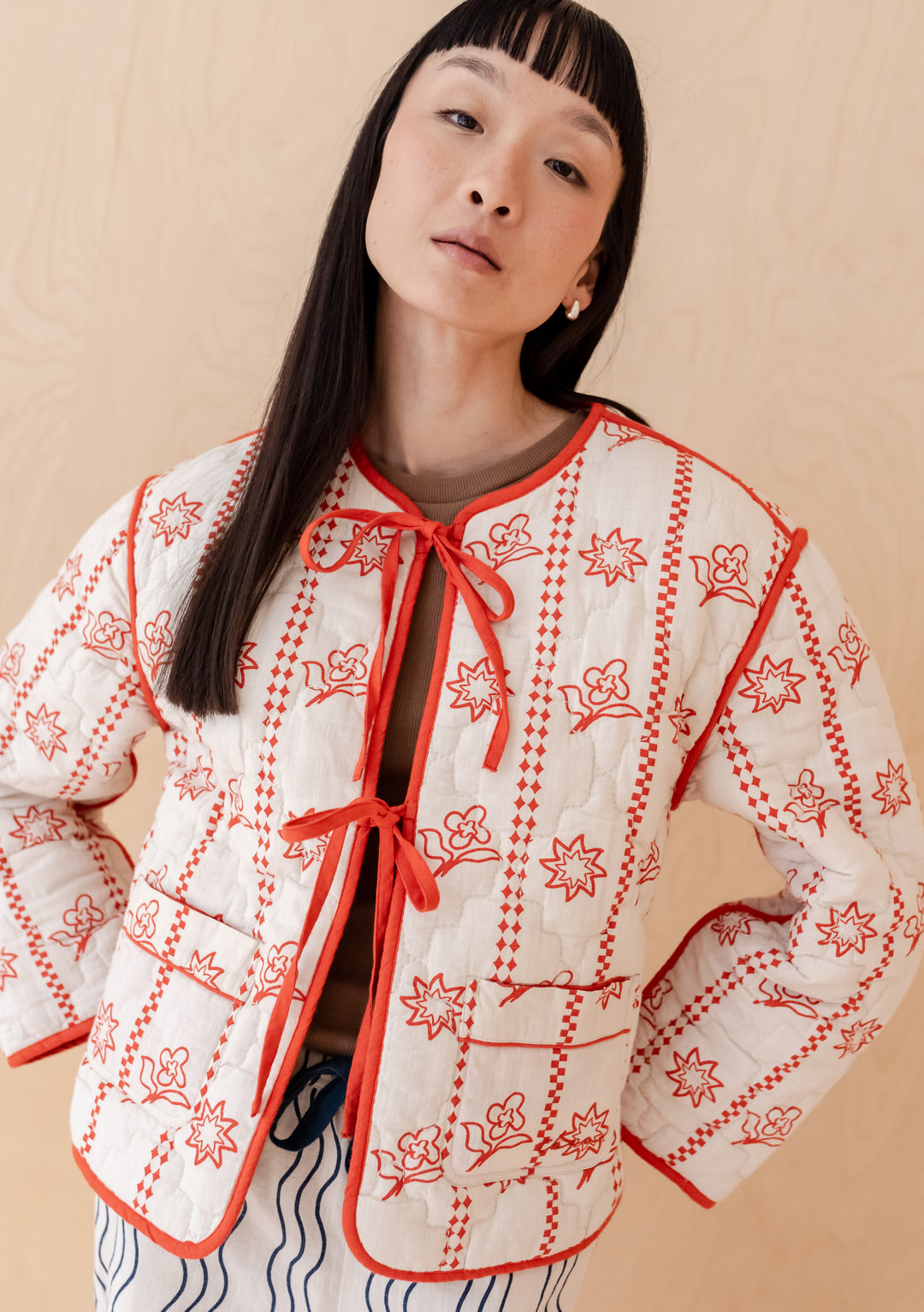 TBCo Quilted Cotton Jacket in orange floral and navy wave print, featuring reversible design with tie fastenings and practical pockets