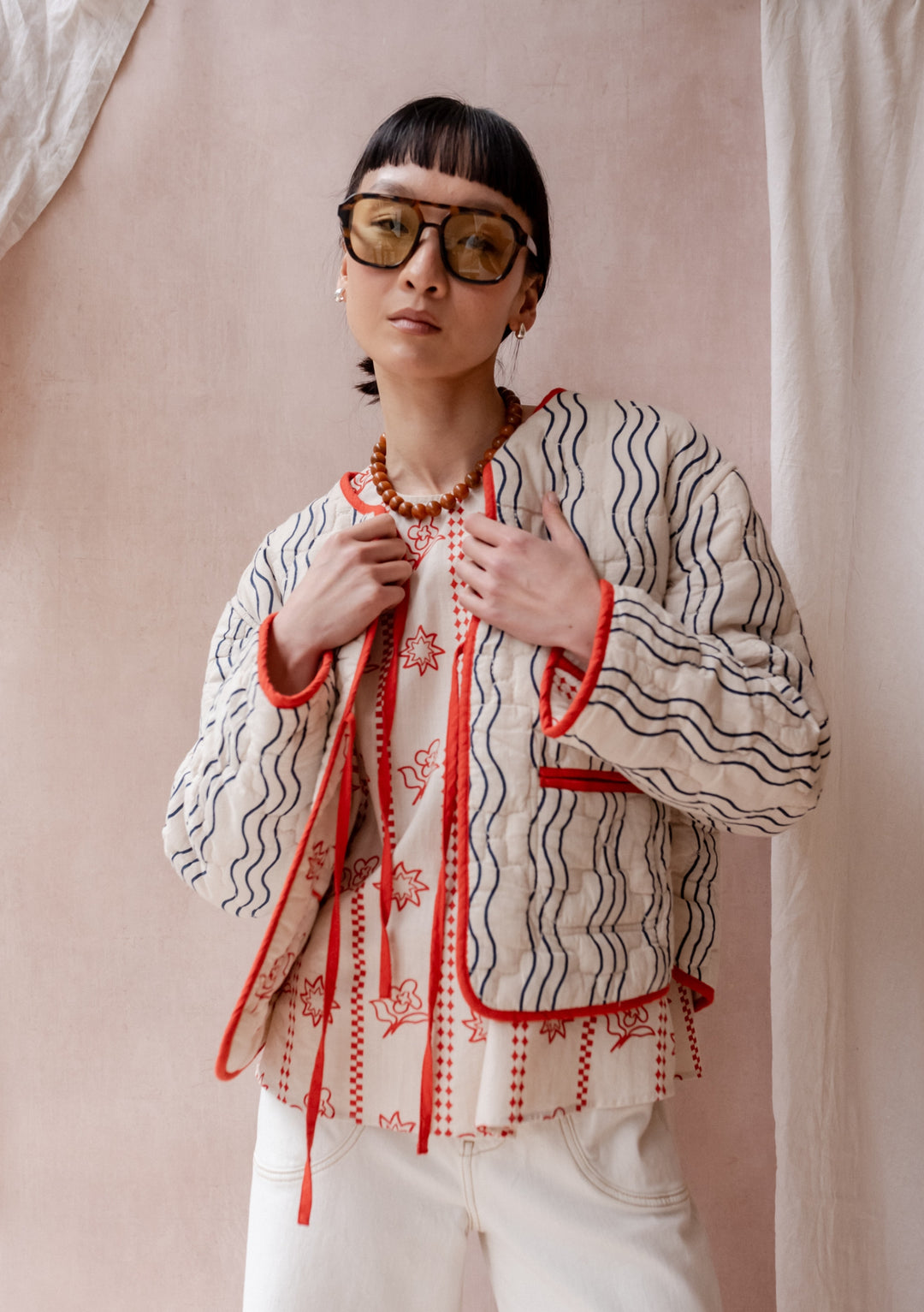 TBCo Quilted Cotton Jacket in Reversible Flora Wave shown with orange-cream floral side, wave-striped detailing and tie closures