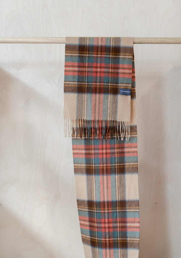 TBCo Stewart Dress Antique Tartan cashmere scarf with fringing displayed on wooden rail, featuring camel, blue and coral plaid