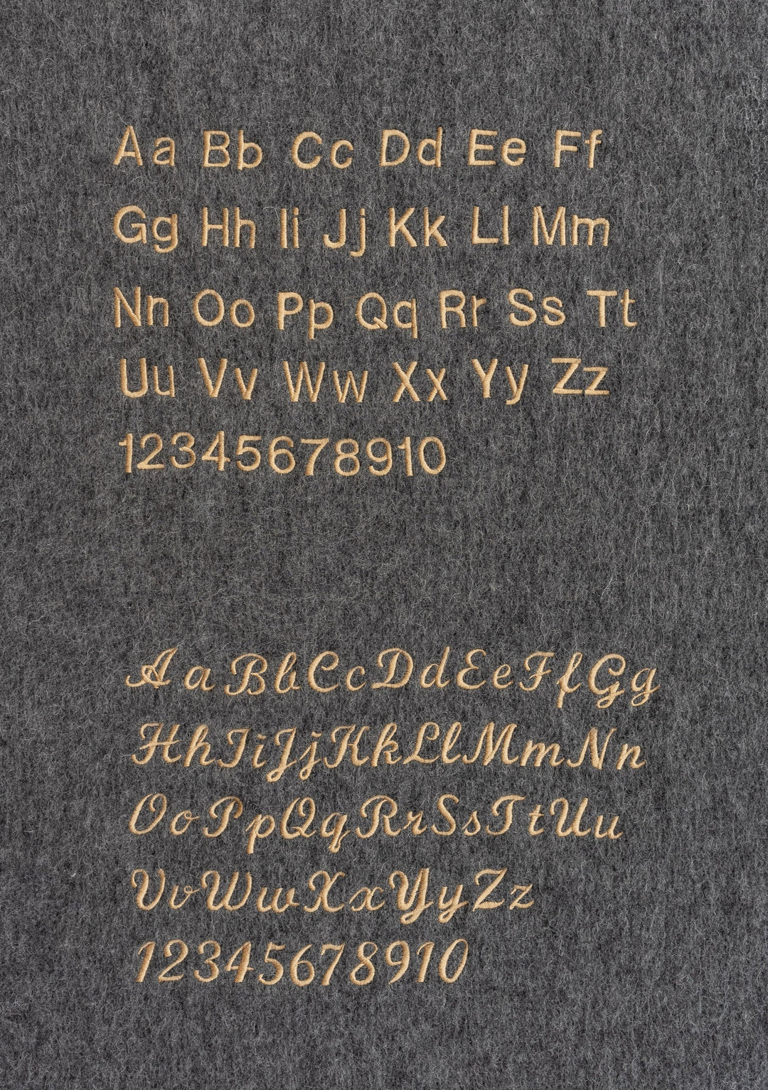 Gold alphabet and numbers displayed in two fonts on grey background, showcasing TBCo's typographic styles