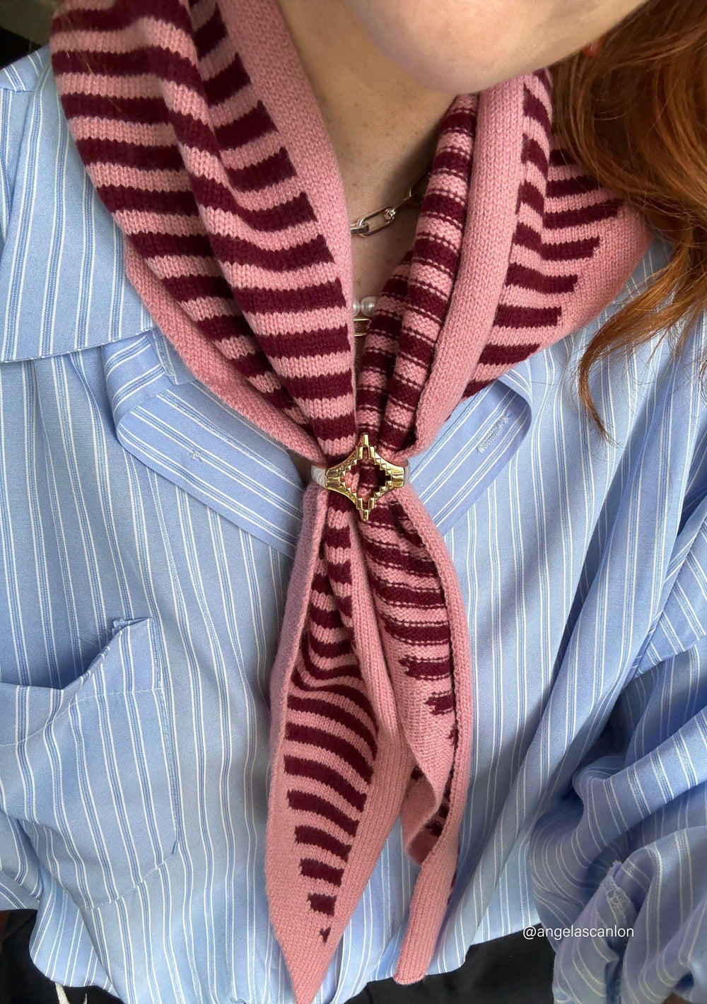 Close-up of TBCo x frkl. Diamond Scarf Ring securing a pink striped scarf styled with a blue shirt and jeans.