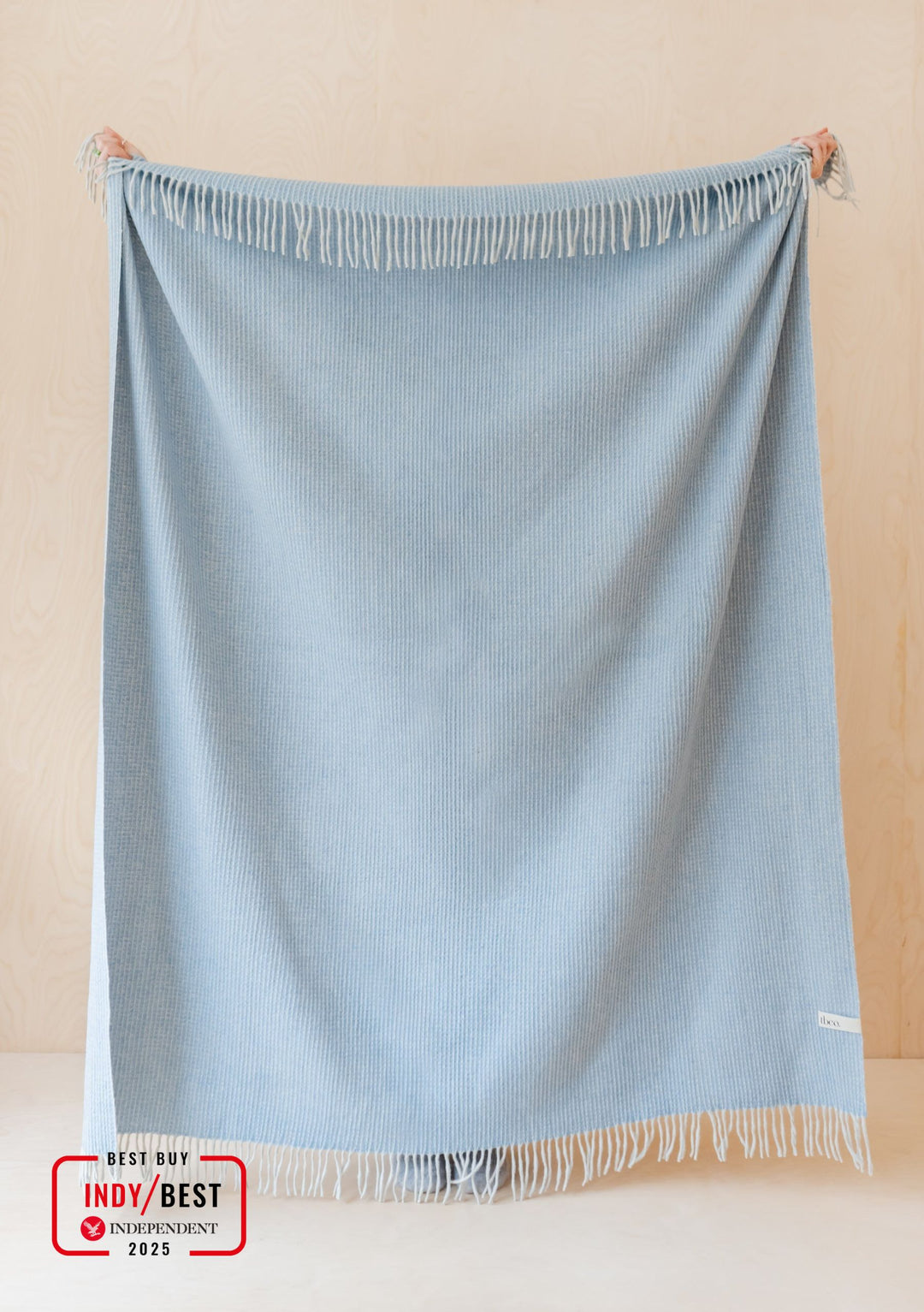 TBCo Recycled Wool Blanket in Azure Waffle displayed with fringed edges on beige background, showing textured waffle weave pattern