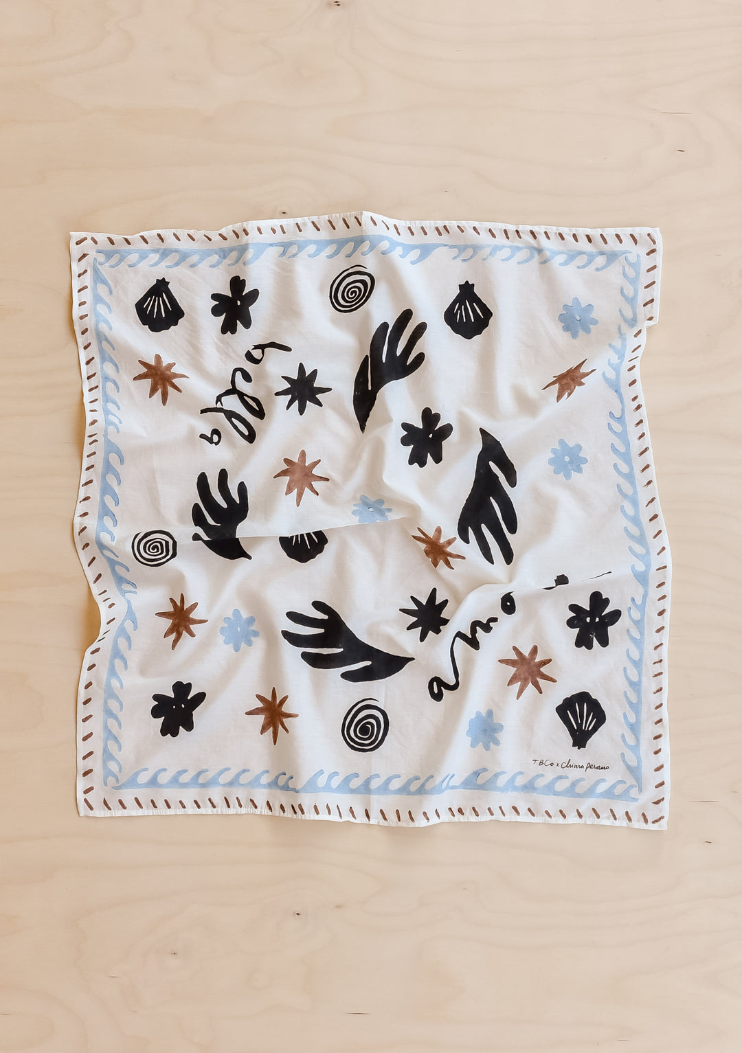 TBCo Chiara Perano Artist Series Cotton Square Triangle Neck Scarf laid flat on a wooden background