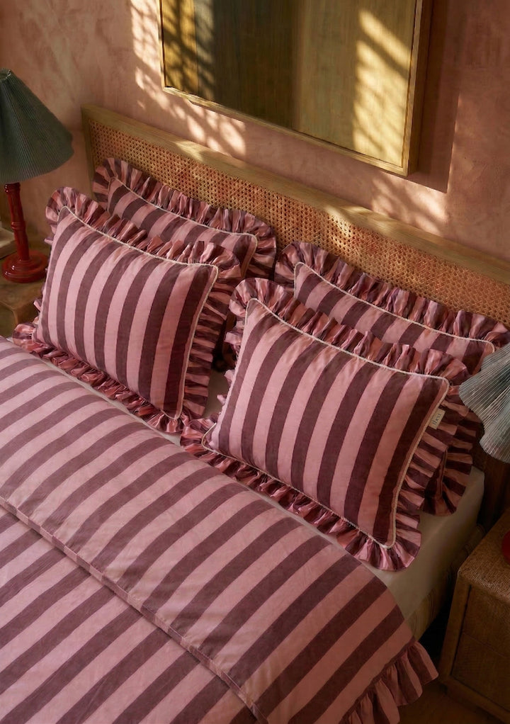 Parure de lit en coton à rayures roses et bordeaux : housse de couette et taies d'oreiller assorties.