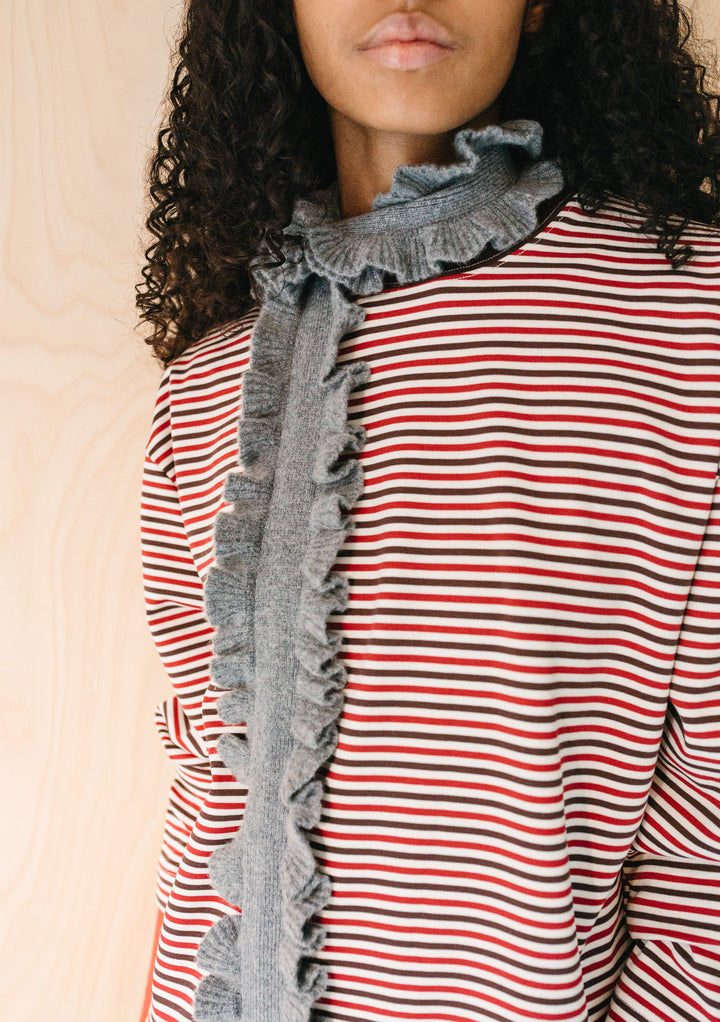 Close-up of TBCo Merino Wool Skinny Scarf in Grey Ruffle wrapped around neck with soft ruffled edges on striped top