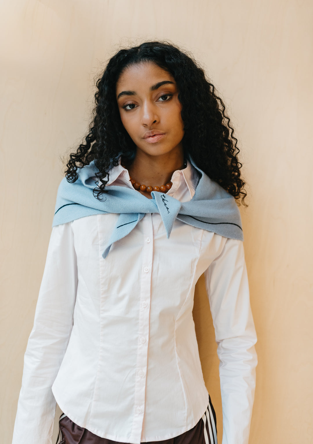 Model wearing TBCo Merino Wool Triangle Scarf in Forget Me Not in pale blue with delicate embroidery draped over shoulders