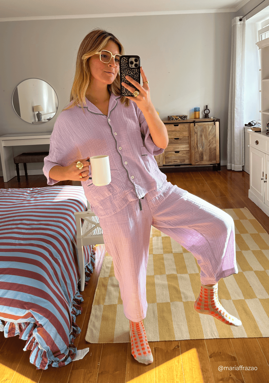 Relaxed lifestyle shot of TBCo Cotton Pyjamas in Lilac featuring cropped sleeves, pockets and scalloped hem trousers on wooden floor
