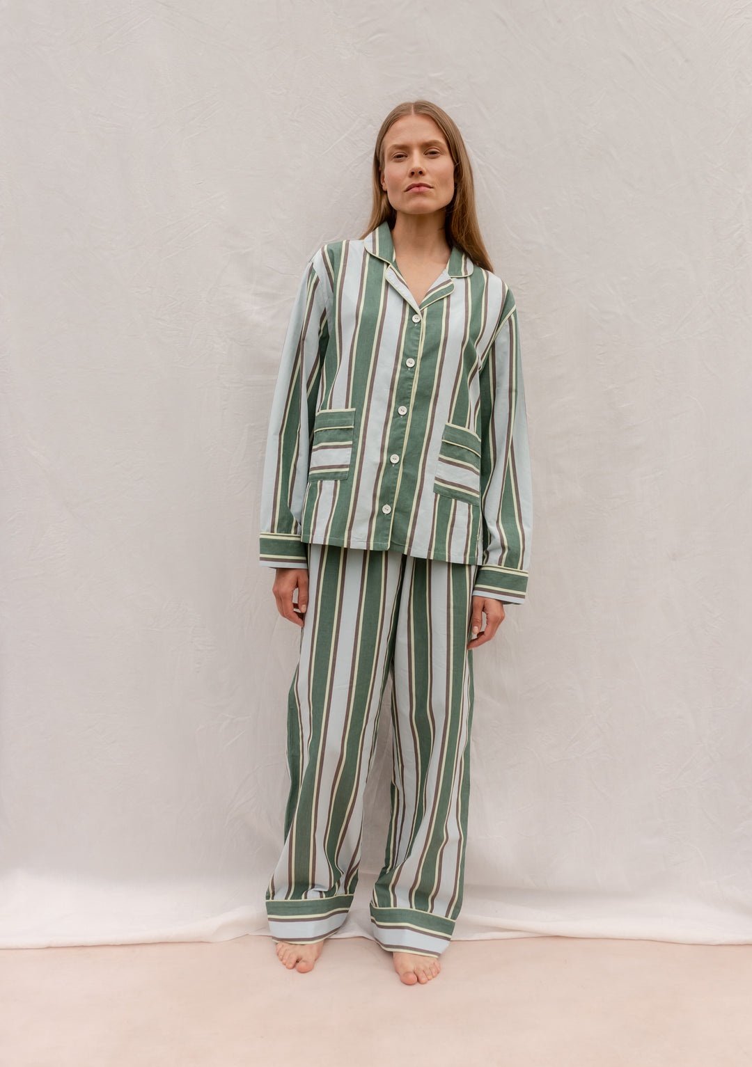 Model wearing TBCo Cotton Pyjamas in Blue Stripe, featuring breathable cotton, tailored stripes, buttons, and pockets.