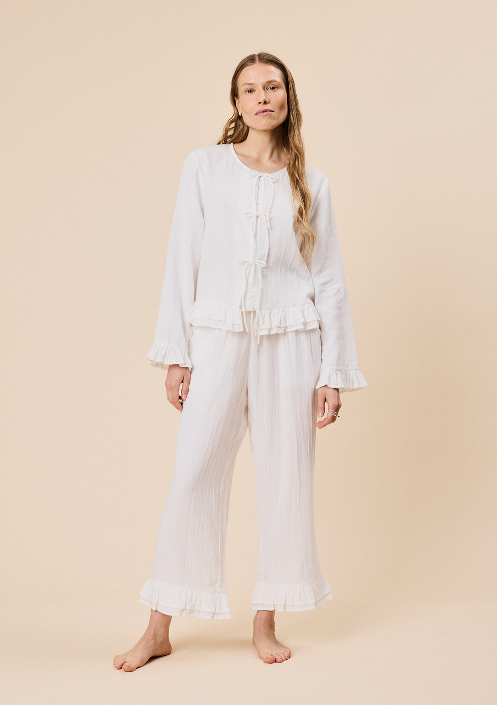 Woman wearing TBCo Ankle Grazer Cotton Pyjamas in White Ruffle, made with natural & recycled fibres, Certified B-Corp, women-founded, designed to make an impact