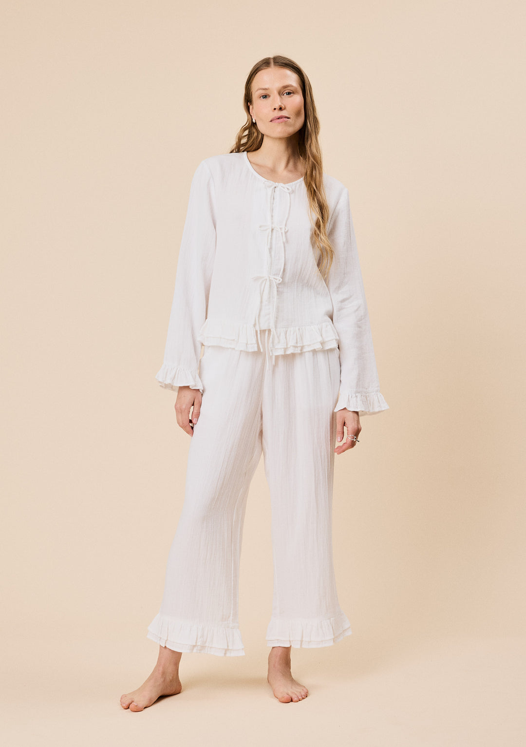 Woman wearing TBCo Ankle Grazer Cotton Pyjamas in White Ruffle, made with natural & recycled fibres, Certified B-Corp, women-founded, designed to make an impact