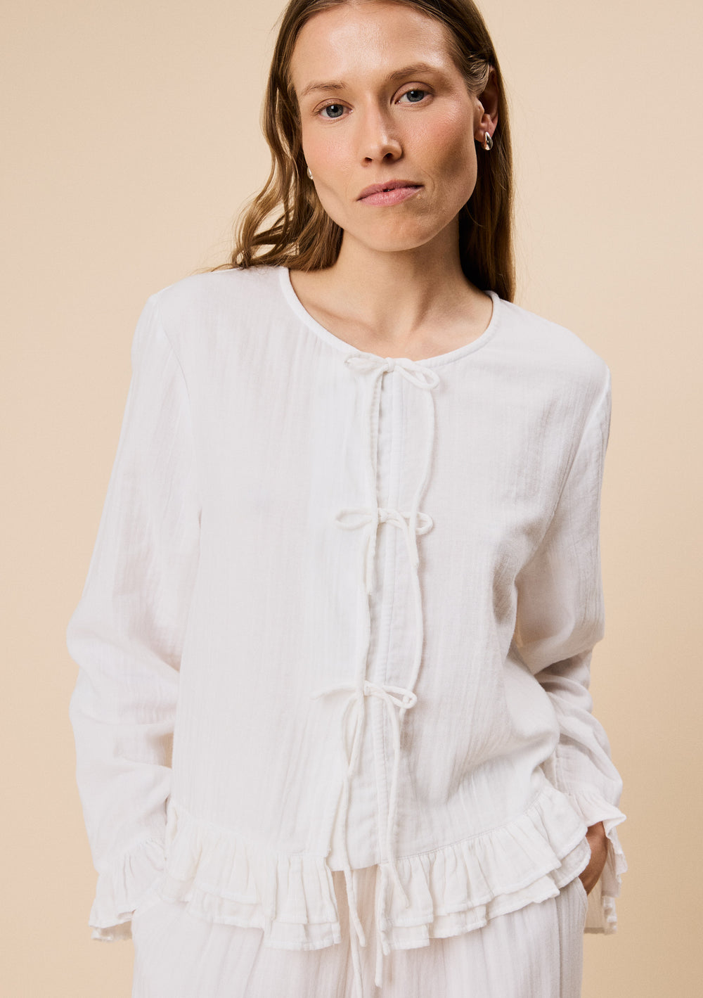Woman wearing TBCo Ankle Grazer Cotton Pyjamas in White Ruffle with natural and recycled fibres, Certified B-Corp, Women-Founded, designed to make an impact