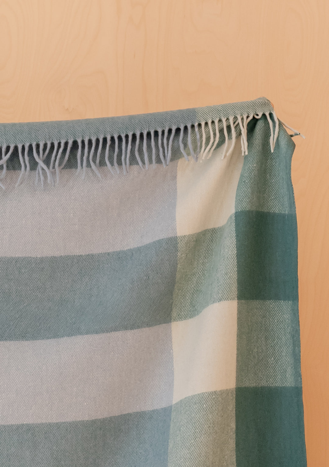 Portrait view of TBCo Recycled Wool Blanket in Blue Bold Check showing fringed edge and soft fibres