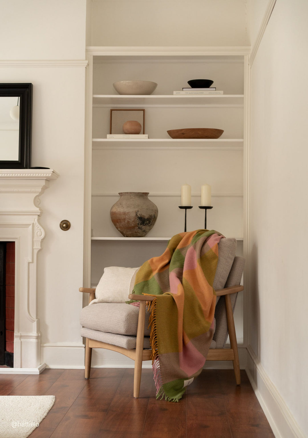 Recycled Wool Blanket in Green Bold Check by TBCo draped over beige armchair in a cosy, neutral-toned room setting