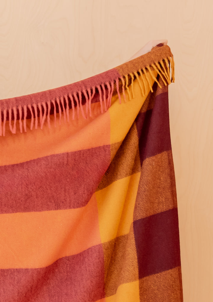 Portrait view gallery 3 of TBCo Recycled Wool Blanket in Ochre Bold Check showing fringed orange and red check pattern