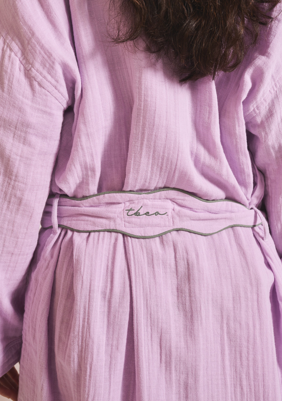 Back view of TBCo Cotton Robe in Lilac showing belt detail and soft cotton gauze texture in portrait format.
