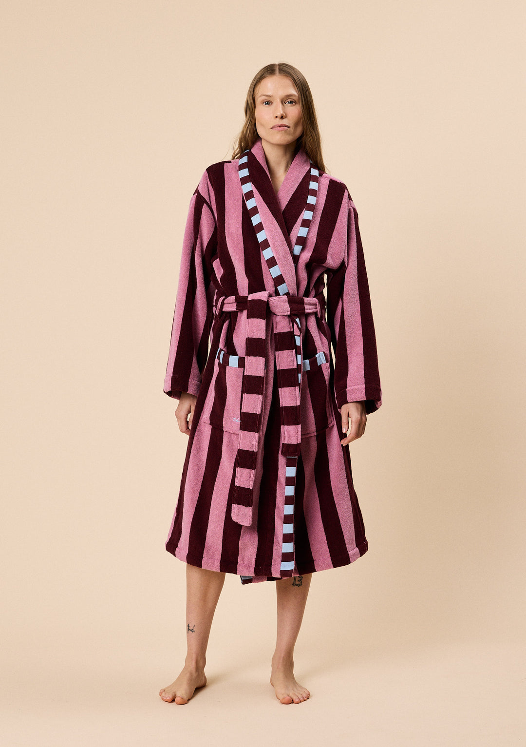 Model wearing a TBCo Terry Cotton Bath Robe in Burgundy Stripe with contrasting blue trim and belt detail