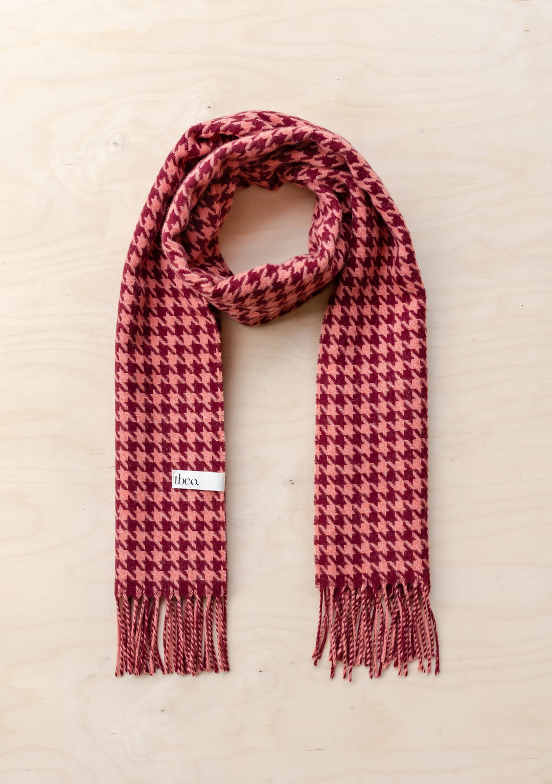 TBCo Lambswool Oversized Scarf in Berry Houndstooth pattern with fringed ends, draped elegantly against light background