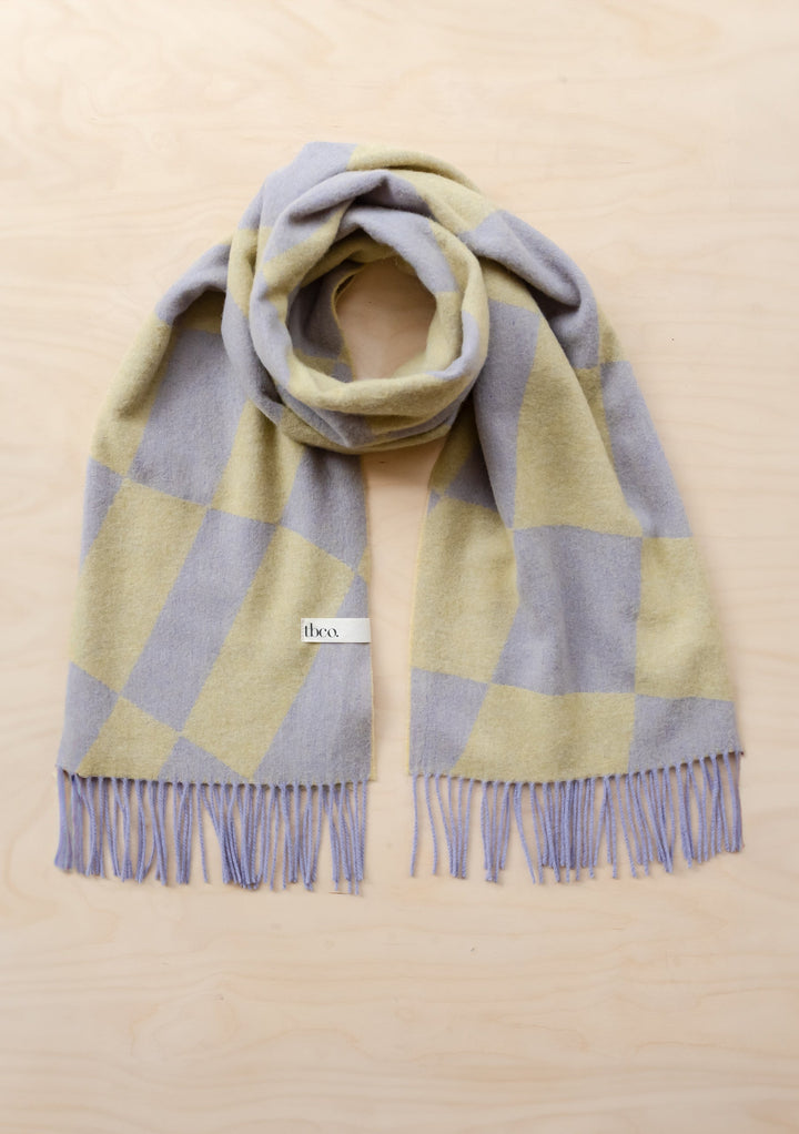 TBCo Lambswool Oversized Scarf in lavender and green organic jacquard pattern with fringe detail, displayed flat on beige surface