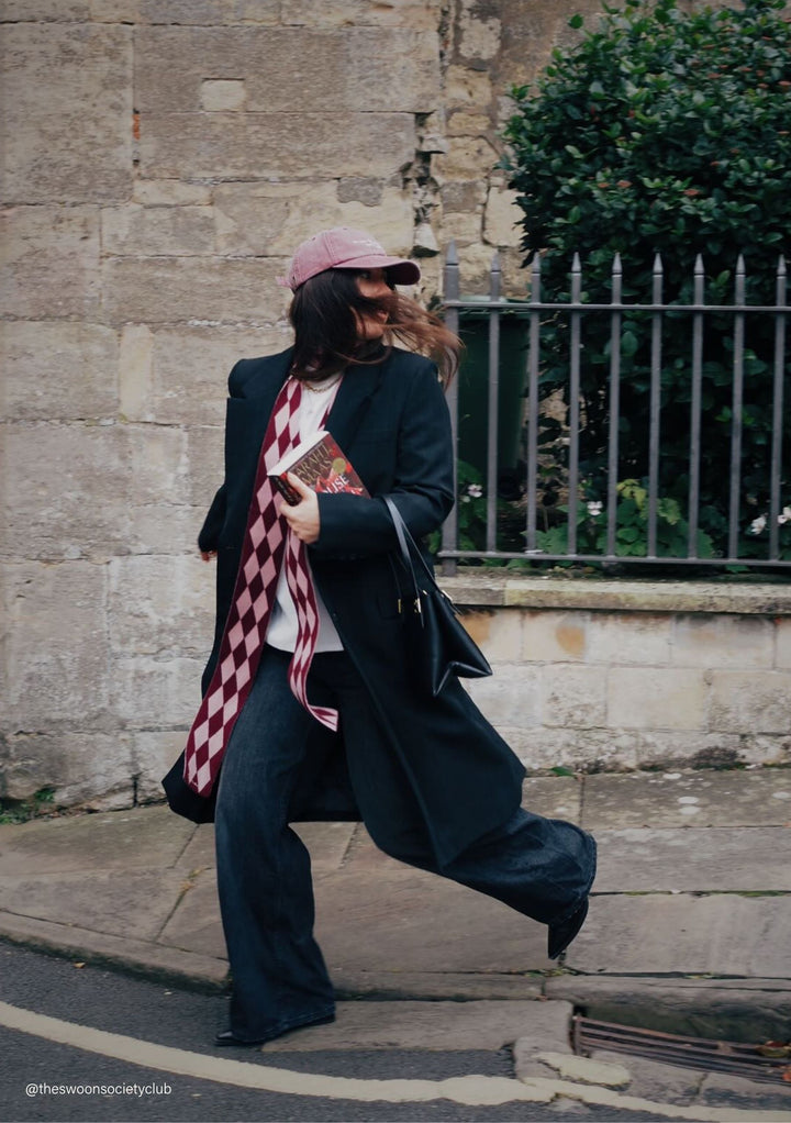 Woman walking wearing TBCo Merino Wool Skinny Scarf in Burgundy Harlequin styled with natural fibres and everyday outerwear designed to make an impact