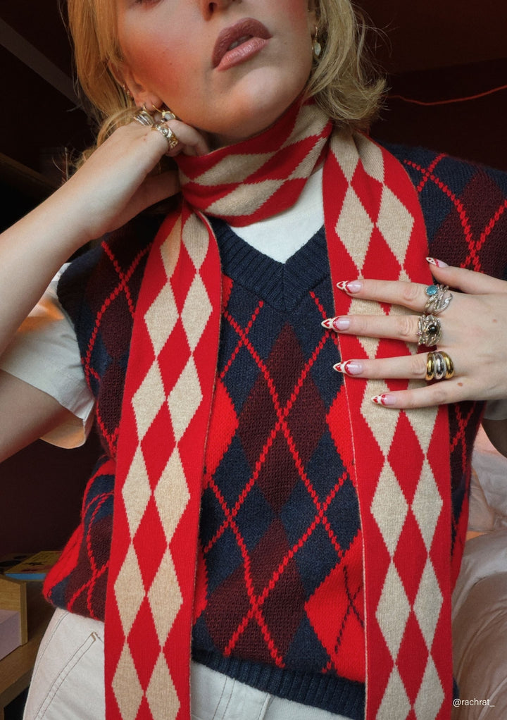 Model wearing TBCo Merino Wool Skinny Scarf in Red Harlequin with natural fibres, designed to make an impact