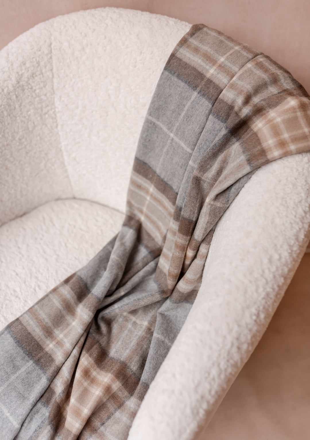 Soft Cashmere Blanket in Mackellar Tartan draped on a white chair, showcasing TBCo’s luxurious wool craftsmanship.