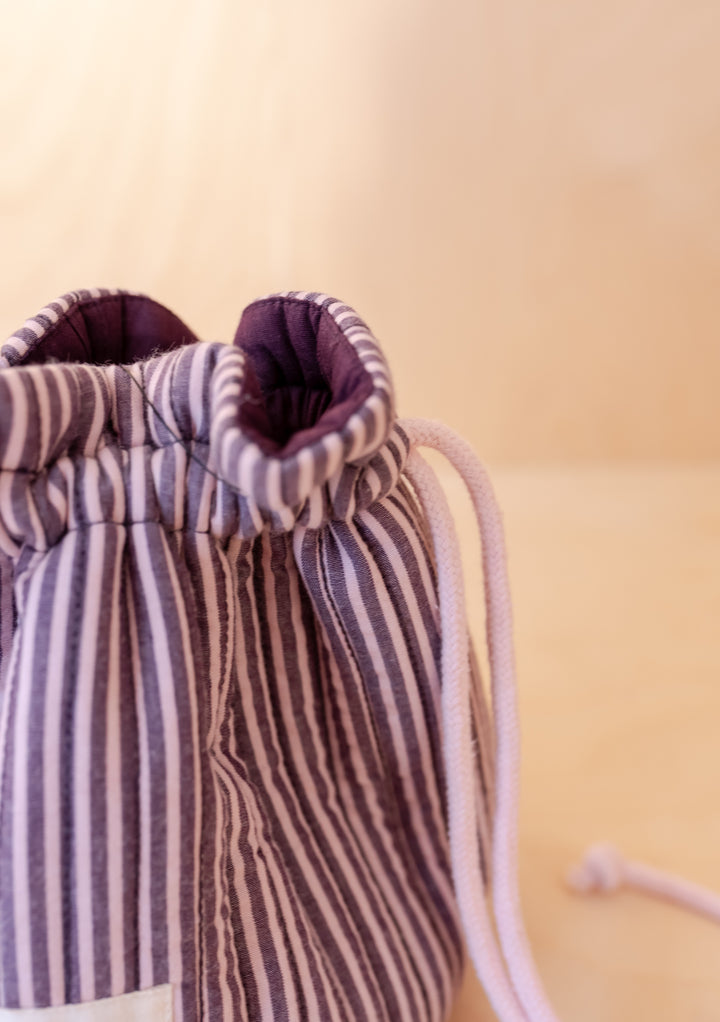Cotton Wash Bag in Burgundy Stripe by TBCo showing quilted drawstring top in portrait gallery shot two
