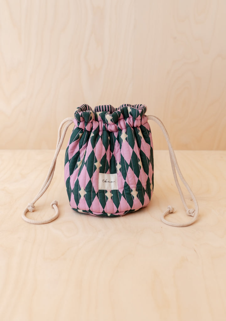 TBCo Cotton Wash Bag in Pink Harlequin pattern with drawstring, featuring a quilted design and fabric label tbco. on a light wood surface.